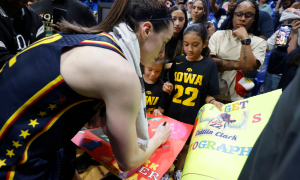 Caitlin Clark signing autographs after Dallas Wings game. The Wings are moving to the Kay Bailey Hutchinson Center in 2026.