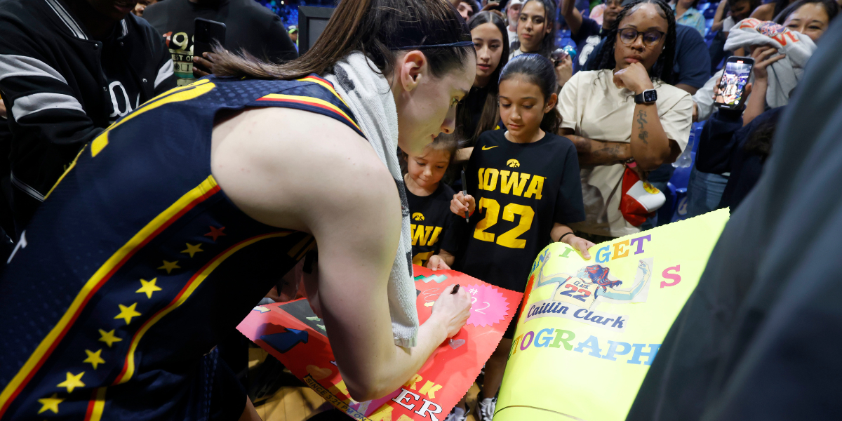 Caitlin Clark signing autographs after Dallas Wings game. The Wings are moving to the Kay Bailey Hutchinson Center in 2026.