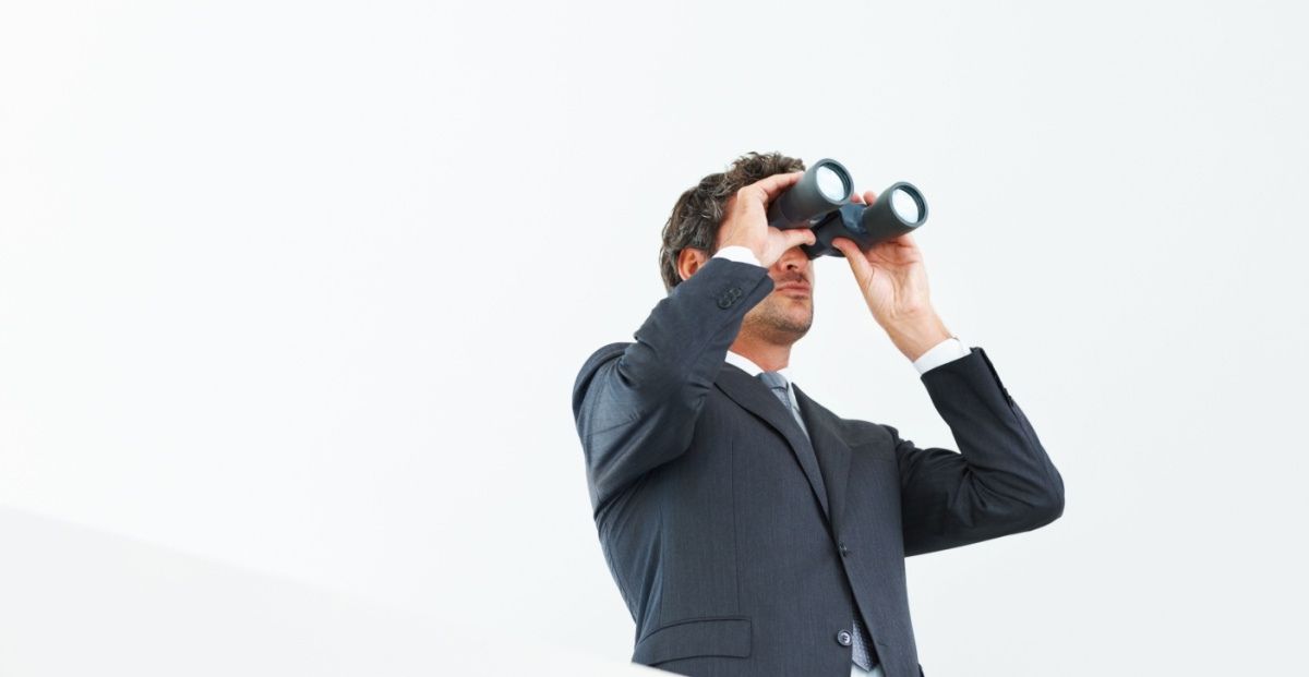 Man looking through binoculars represents legal TX sports betting still a few years off