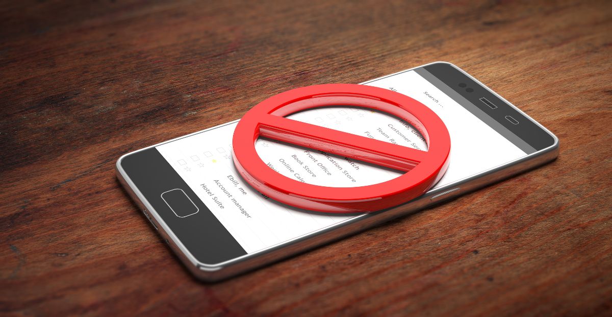 a ban symbol sitting atop a mobile phone